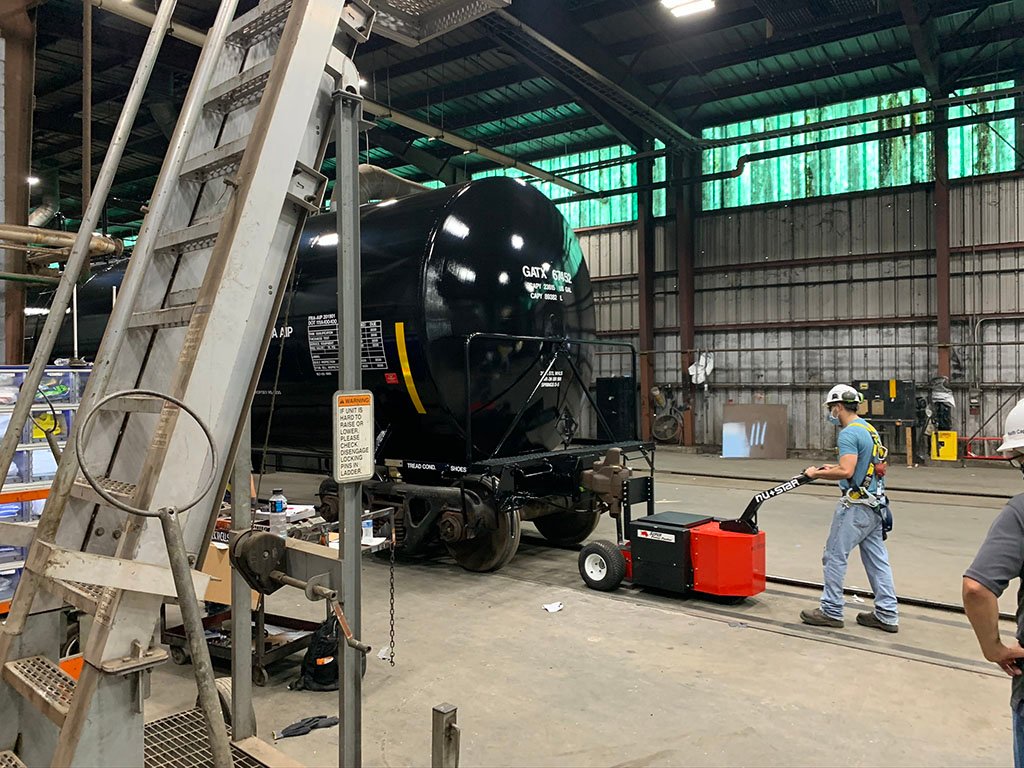 Heavy-Duty Trailer Mover™ towing a tanker rail car on industrial tracks