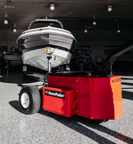 Heavy-Duty Trailer Mover™ towing a large boat on a trailer in a marina setting