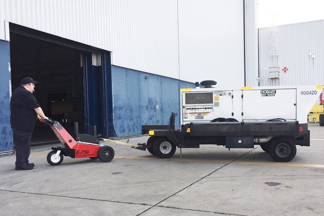 E-750 Trailer Mover™ towing a heavy-duty generator on a trailer in an industrial setting